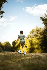 child kicking a soccer ball