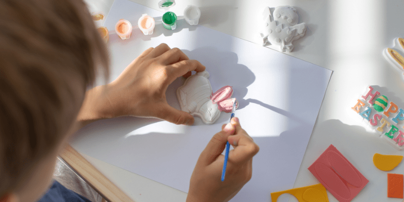young child painting ceramic bunny