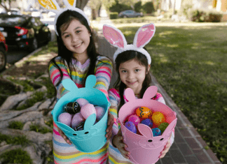 girls hold Easter baskets with plastic eggs inside