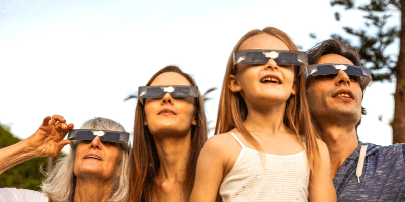 family viewing solar eclipse with eclipse glasses