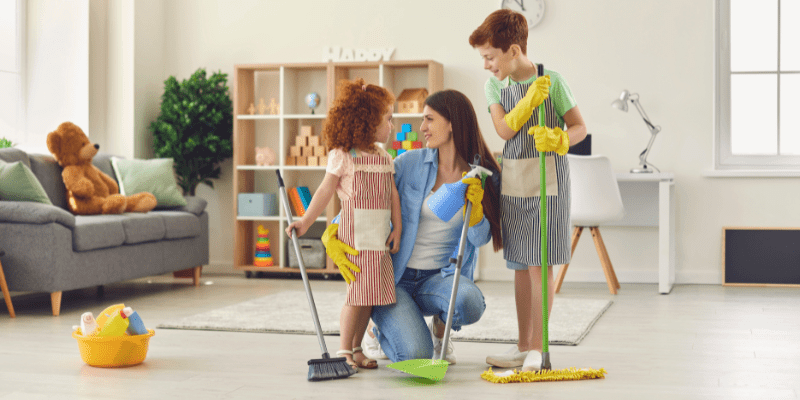 mother and children with mops and broom work on maintaining a clean home