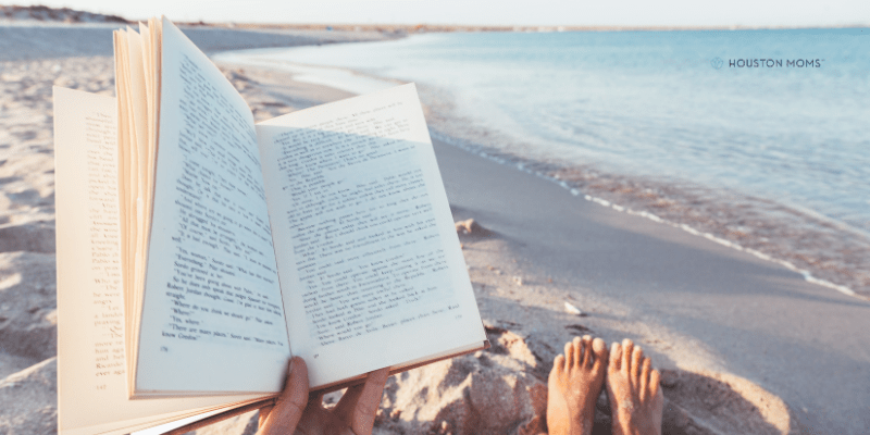 woman reads book on beach