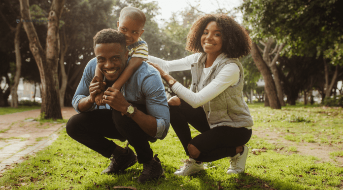 The Consequences of Pregnancy: Co-Parenting man and woman playing outside with child