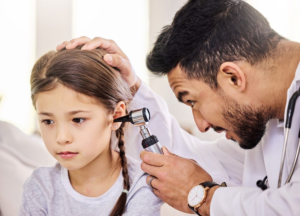 a doctor looking into a little girl's ear
