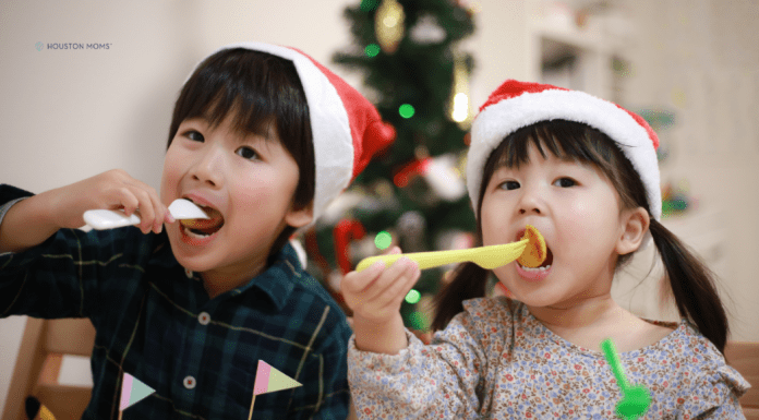 children with Santa hats taking a bite of a holiday meal