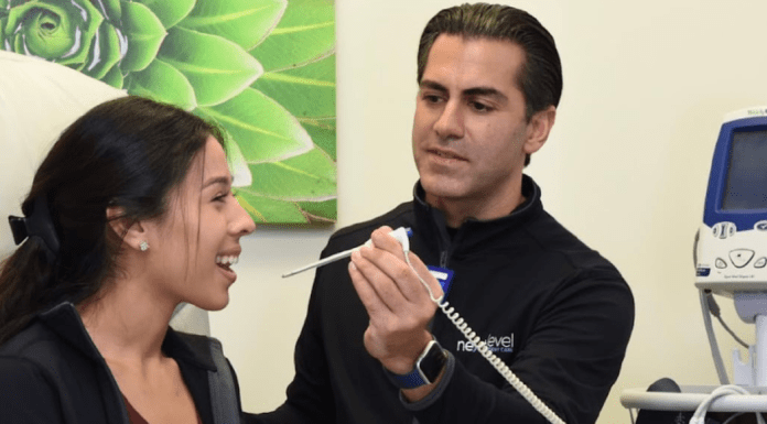 New Look, Same Values: Next Level is Committed to Houston Families Man taking woman's temperature in clinic