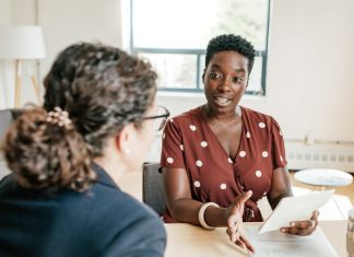 Knowledge is Power: Guidance for Divorce Two women talking at a table while holding papers