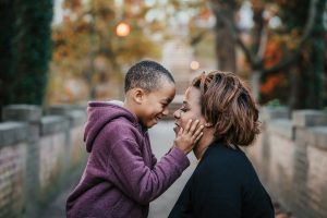 son with hands on mother's face