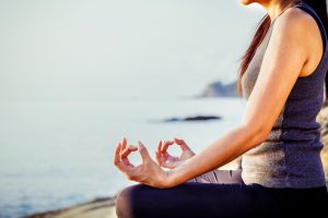 The woman meditating in a yoga pose on the tropical beach. Female meditating overlooking the beautiful sunrise. Healthy mind body and spirit concept. <a href="https://www.pond5.com/stock-images/photos/item/70198771-woman-meditating-yoga-pose-tropical-beach">Stock Image</a> provided by kerdkanno, from <a href="https://www.pond5.com/">Pond5</a>