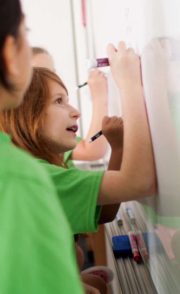 Kids drawing on a white board at theatre camp
