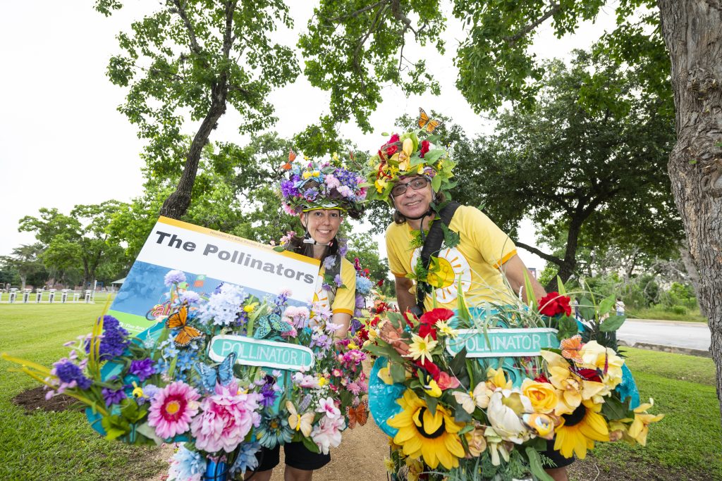 Two girls smile with their bikes covered in flowers.