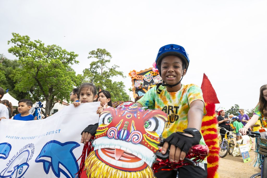 A boy is riding a bike decorated like a dragon