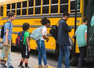 children getting on school bus