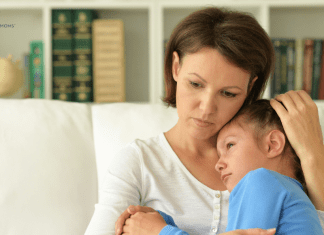 mother and young child on the couch, cuddling in grief