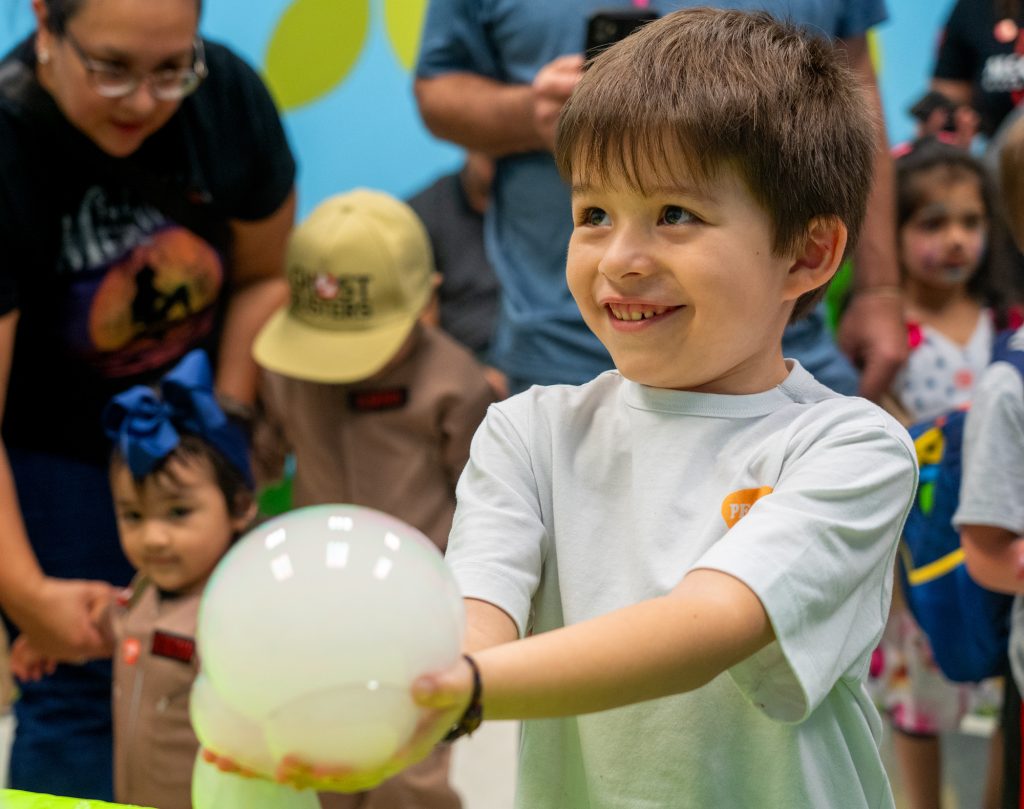  A boy holds a smile bubble at the children's museum