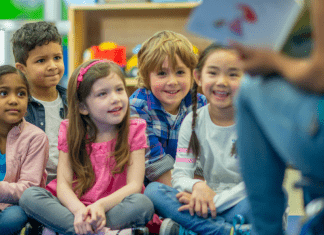 teacher reading to group of students sitting on floor