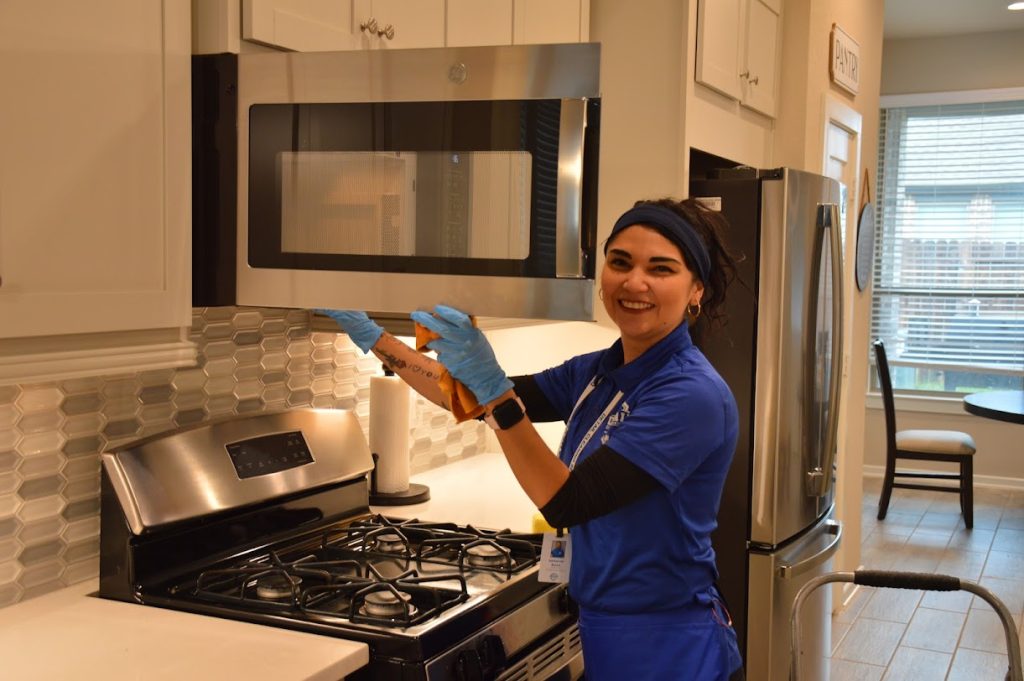 Woman professionally cleaning microwave