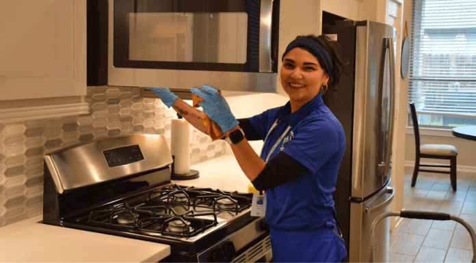 Why Busy Moms in Houston Swear by Professional Cleaning woman cleaning microwave