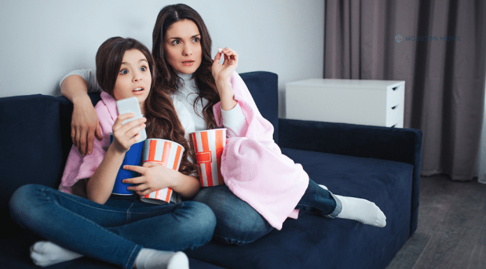 Watching Late 90s/Early 2000s RomComs Through a Modern Lens mother and daughter sitting on couch with popcorn