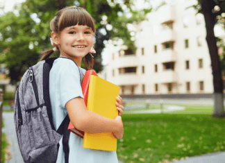 girl with backpack on holding folders