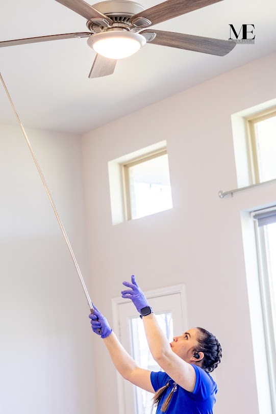 woman cleaning ceiling fan