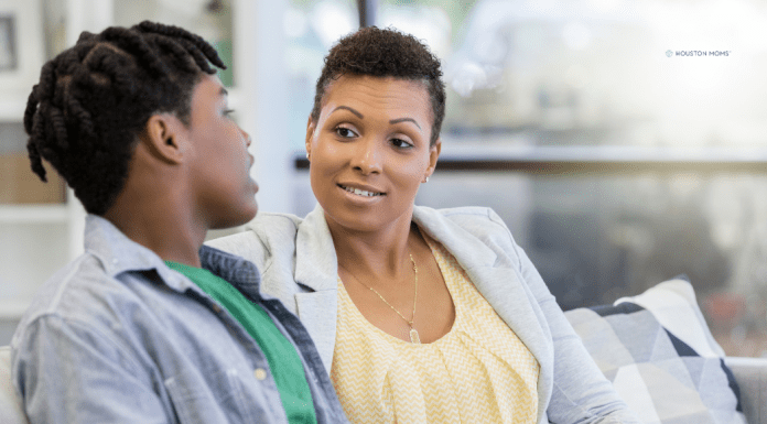 mother and college aged son sit and talk on couch