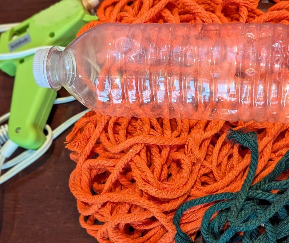 water bottle, glue gun and yarn
