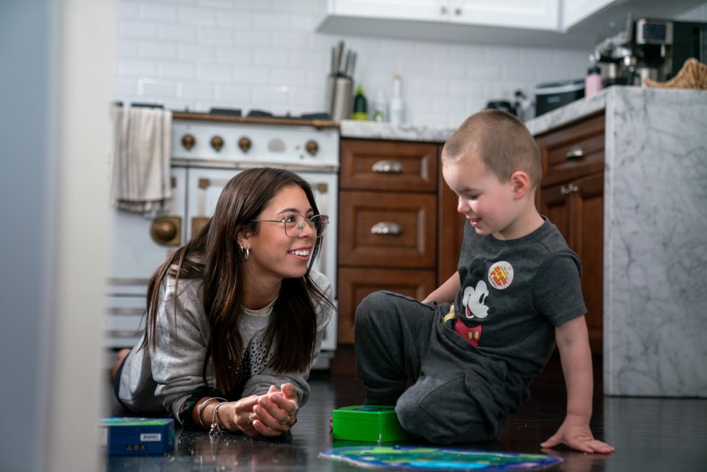 Young woman and toddler sit on floor