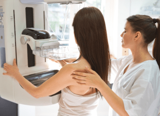 Health Screenings Every Mom Should Prioritize nurse assists woman getting mammogram