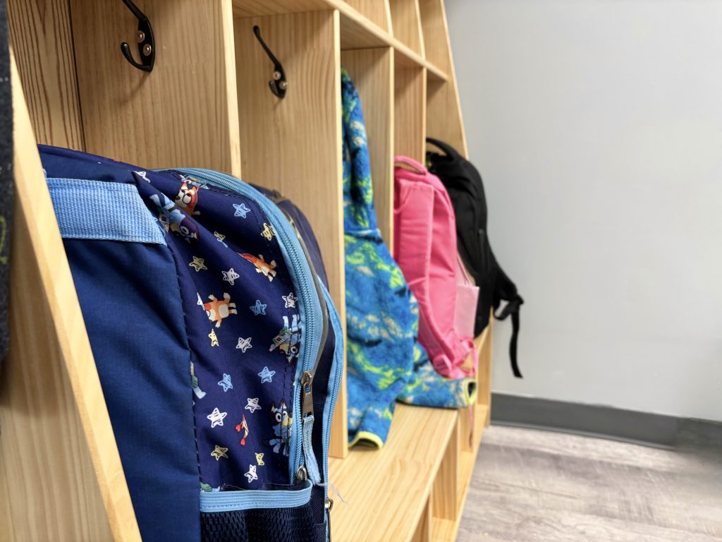 cabinet with hooks holding backpacks