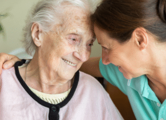 younger woman sits with younger woman with Alzheimer's