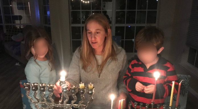 mother and children light a menorah