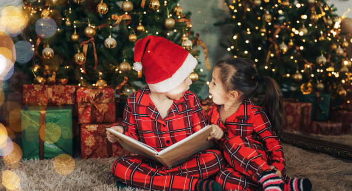 Holiday Books children reading holiday books under the Christmas tree