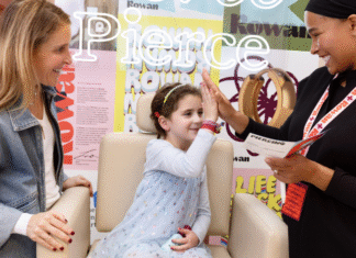 Why Rowan Should Be On Your Holiday List girl getting her ears pierced high fives the piercer while her mom watches, smiling
