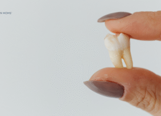 fingers holding tooth
