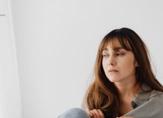 woman sits on floor with sad expression