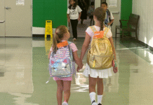 Sugar Mill Elementary, sisters holding hands, walking down hallway