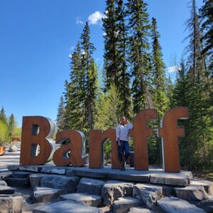 woman standing on ledge with letters Banff