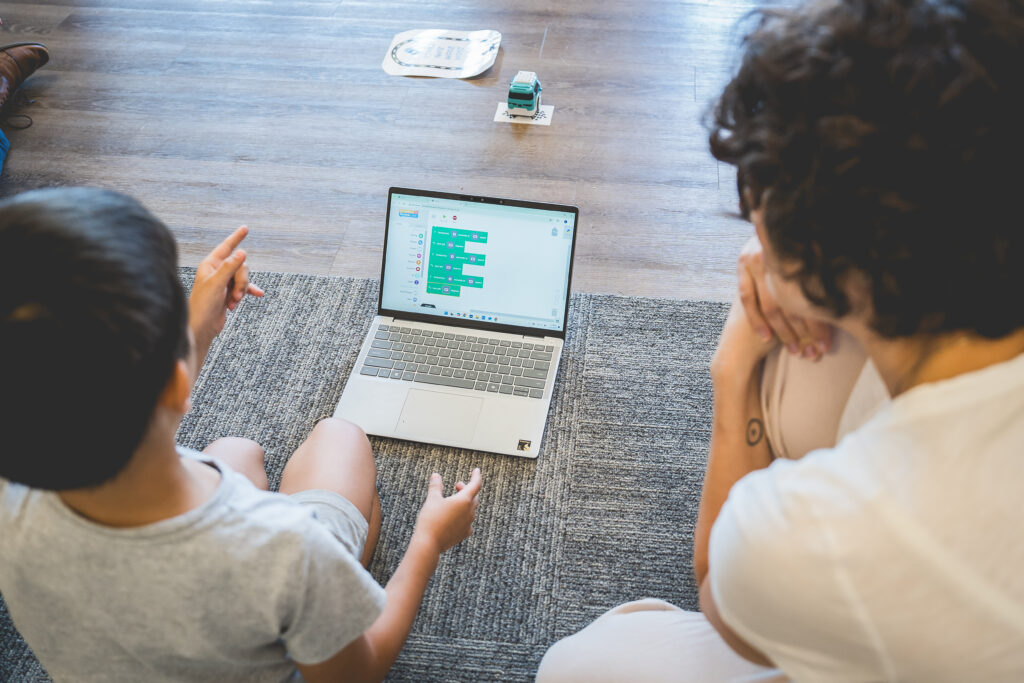 advanced students sit on floor doing project on computer