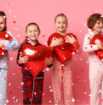 kids holding heart balloons surrounded by cofetti