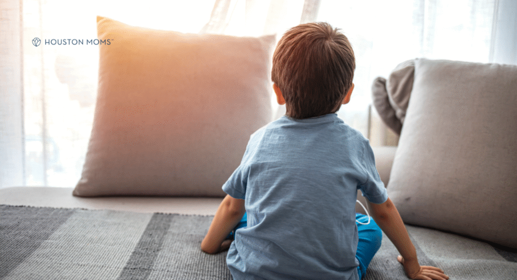 child sitting on floor looking at pillow