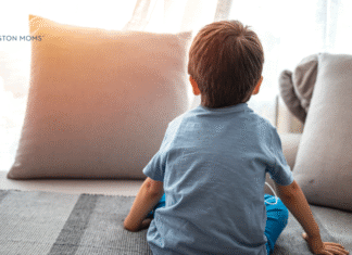 child sitting on floor looking at pillow