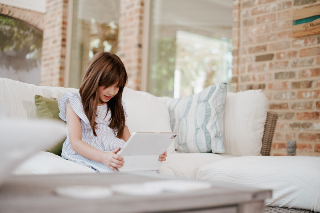 girl sitting on couch looking at computer