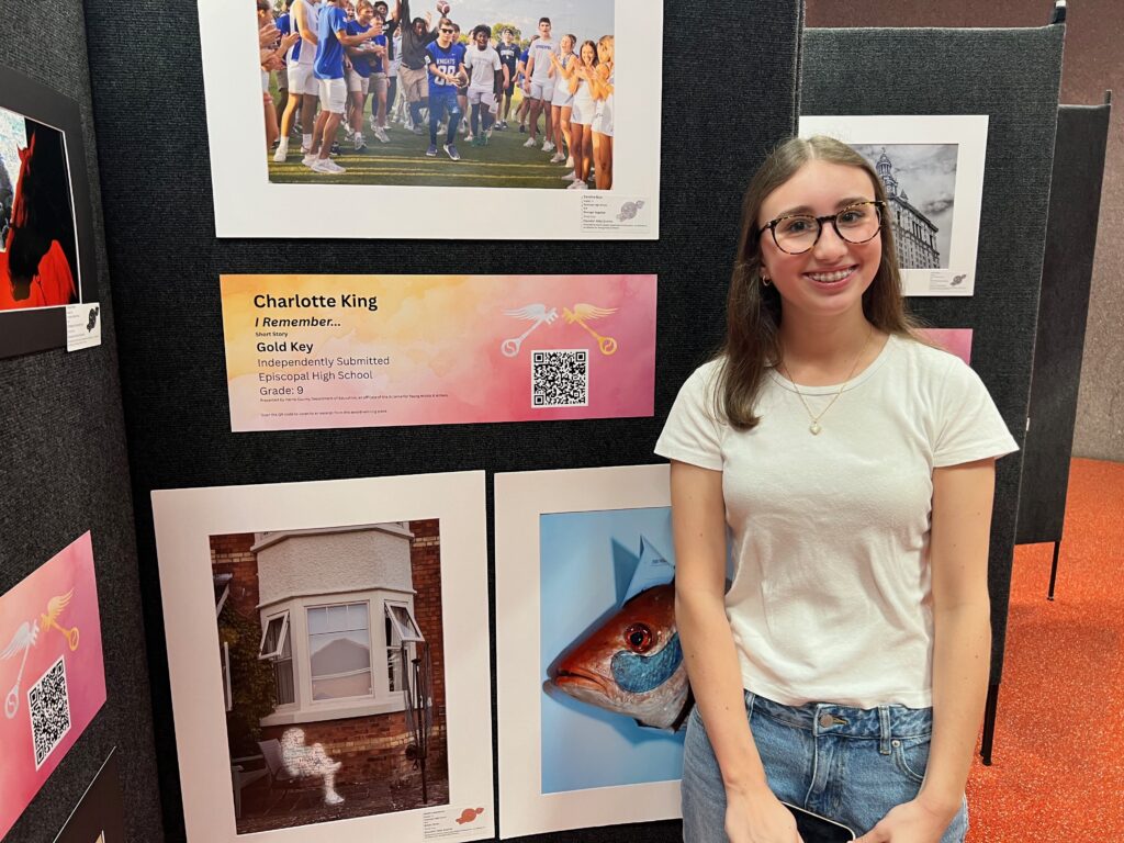girl standing in front of paintings 