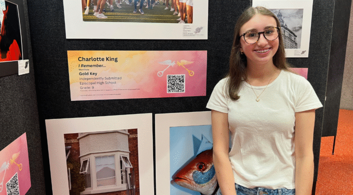Raising Readers and Writers in a Digital World girl standing in front of paintings and a plaque and QR code