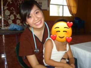 woman in scrubs holds child in her lap