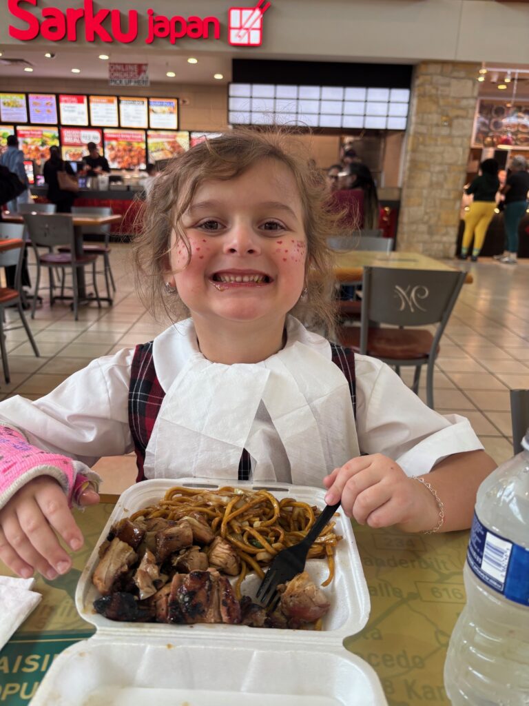 girl sits in front of a container of Chinese food