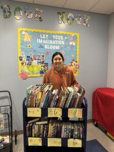 woman standing behind a cart filled with books