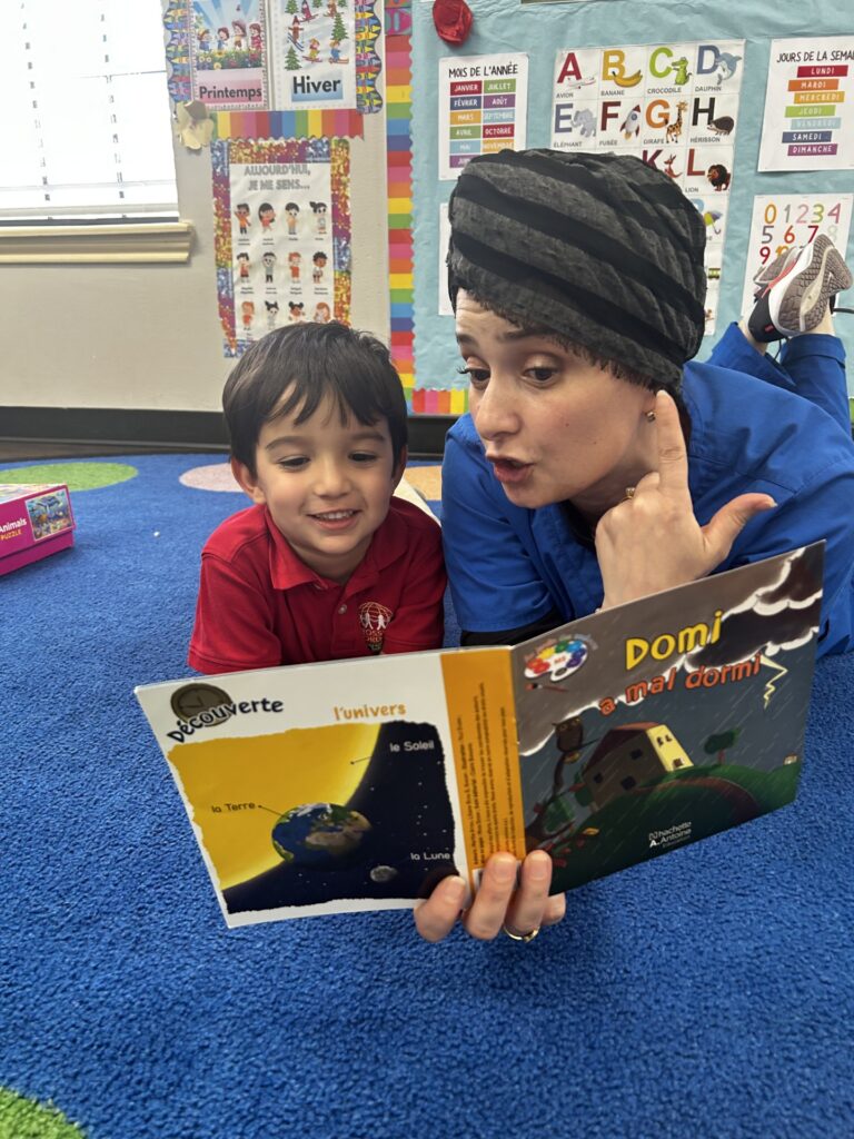 A preschool teacher reads a book to a student