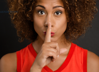 The Consequences of Pregnancy: The Quiet Part Out Loud woman holding finger to her mouth indicating quiet